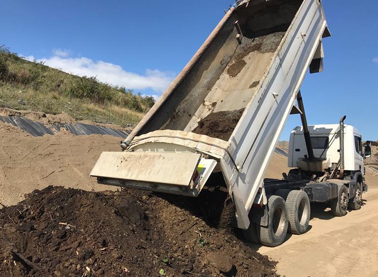 soil being emptied from back of a truck